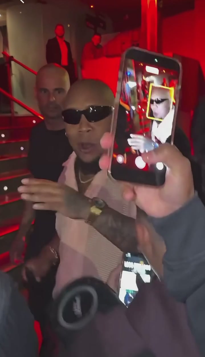 Source frame where a phone partly covers the main performer near the end of the clip